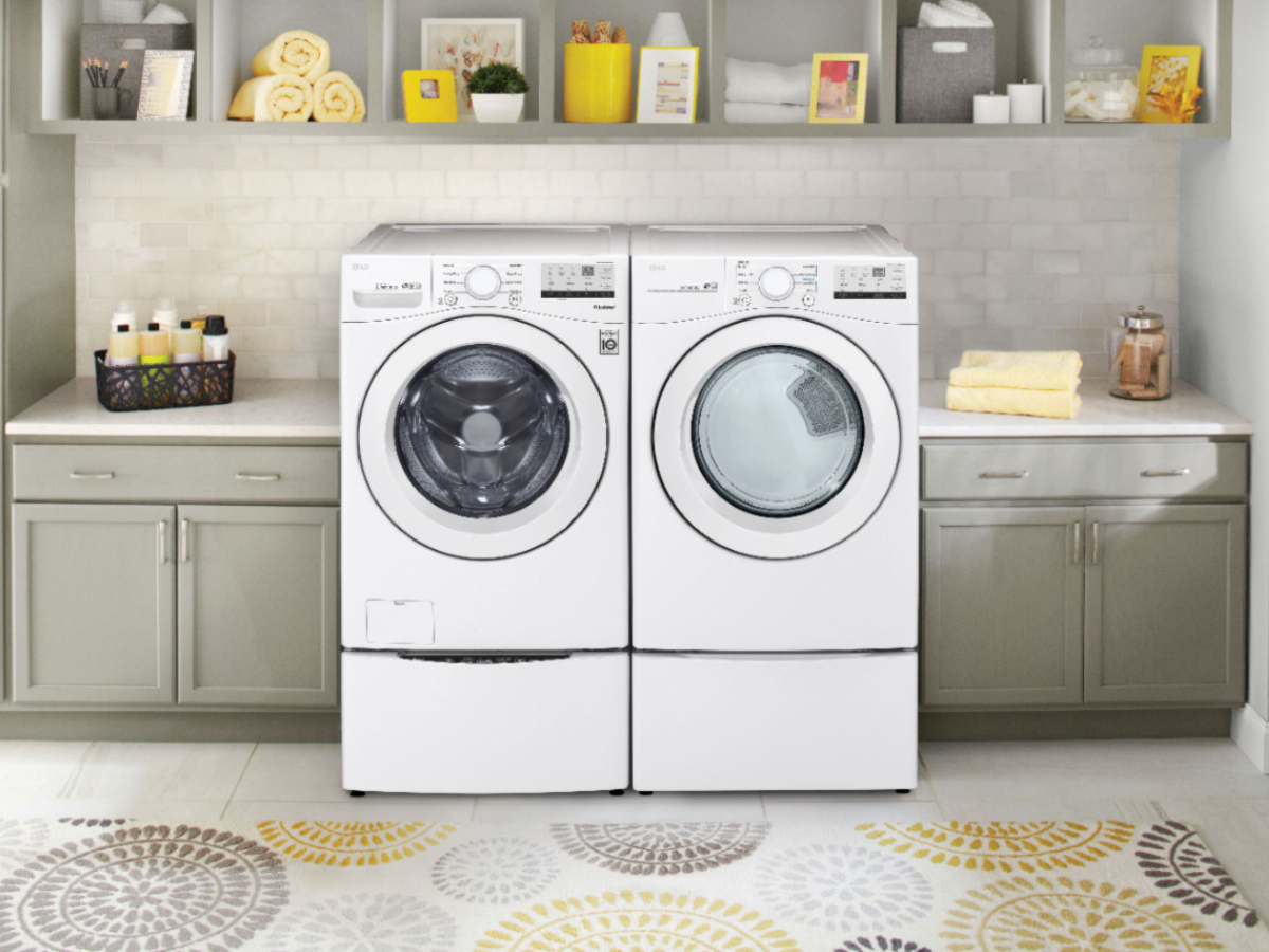 LG 4.5 cubic foot high efficiency stackable front-load washer with 6Motion technology and 7.4 cubic foot electric dryer in a laundry room with pale green cabinets and marble countertops.