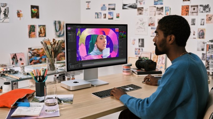 Una persona sentada en un escritorio usando una Mac Mini.