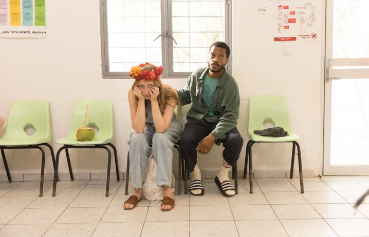 Anna Konkle and Jermaine Fowler sit in the waiting room of a hospital during a scene from The Drop.