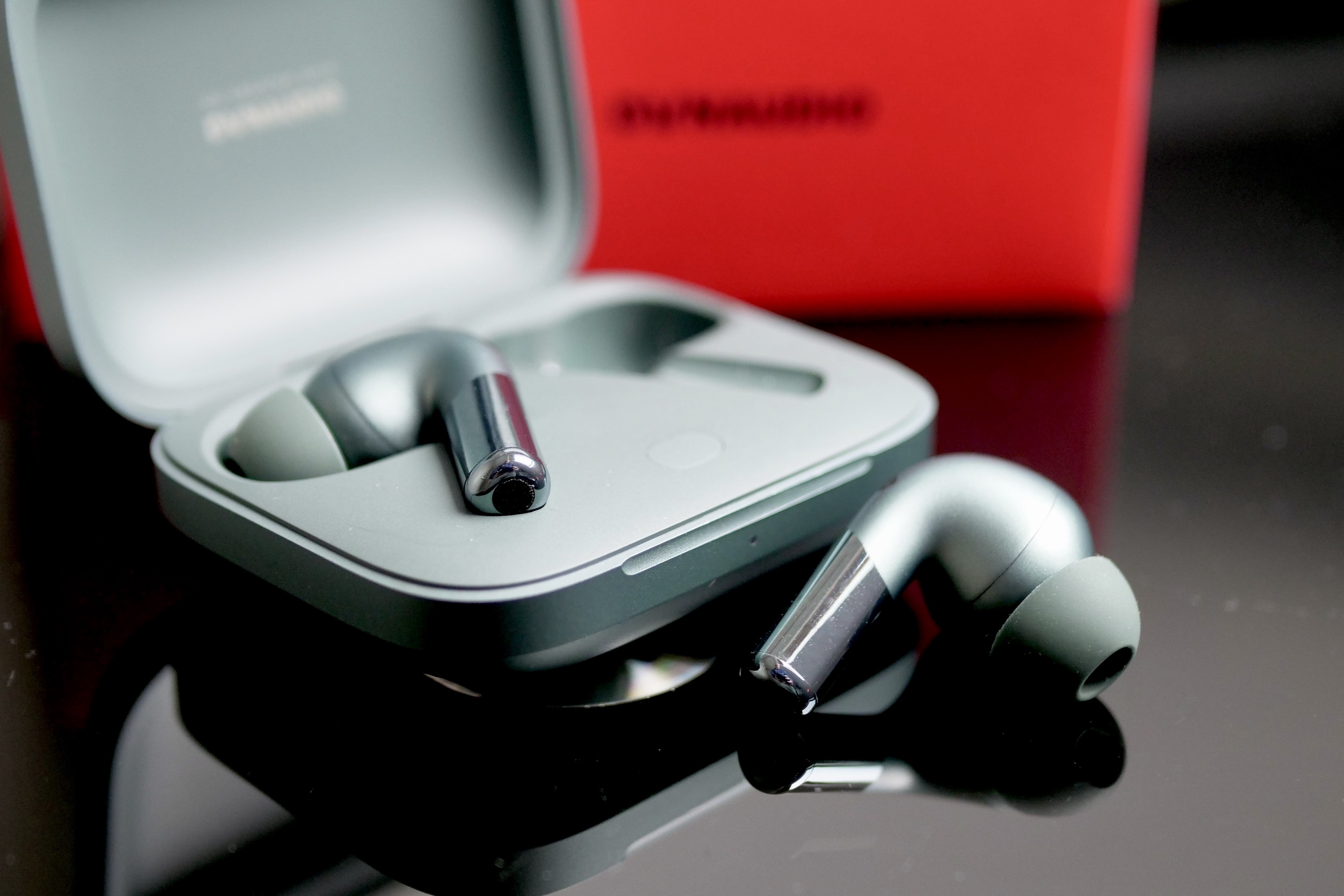 OnePlus Buds Pro 2 earbud next to its open case.
