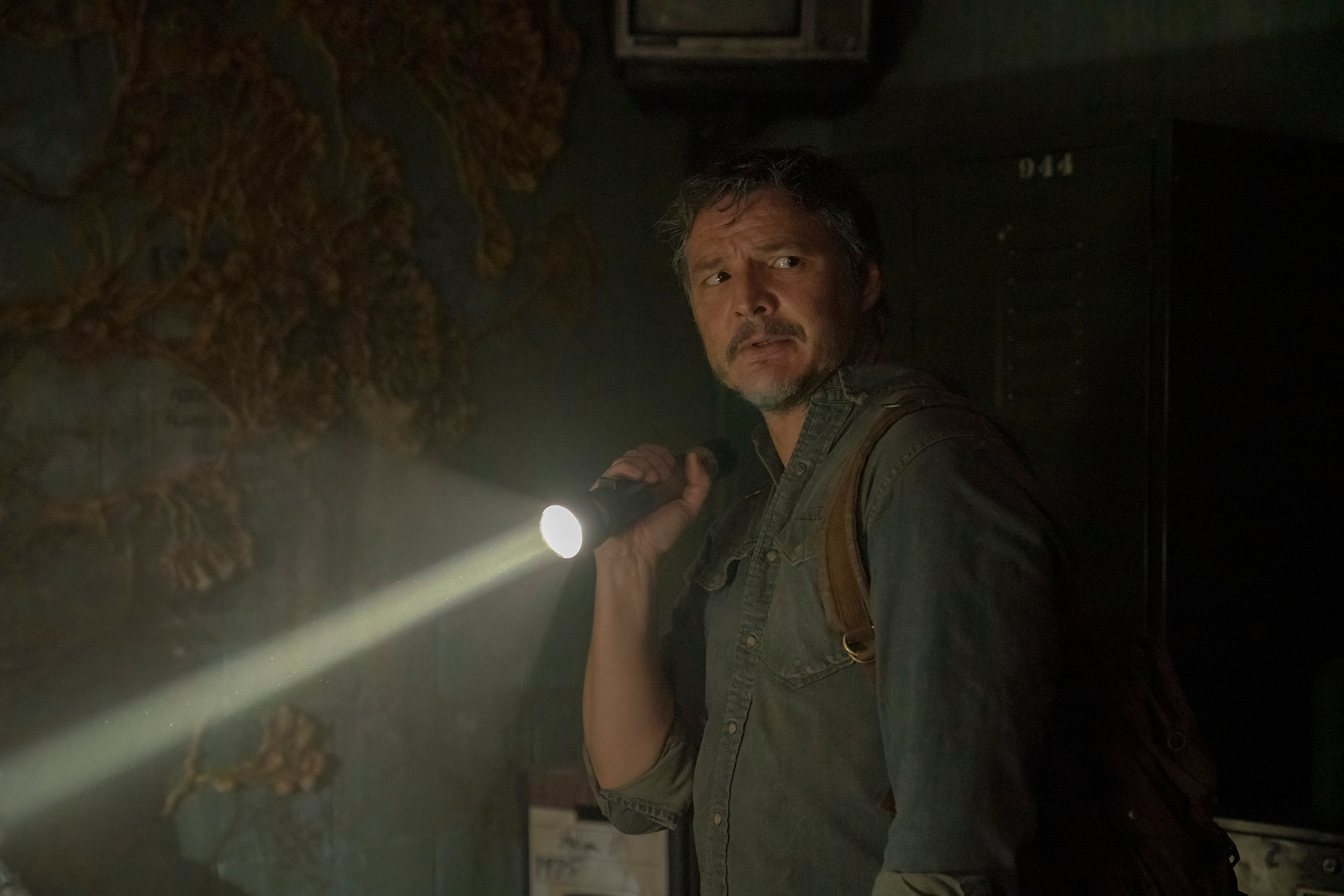 Pedro Pascal hält in The Last of Us eine Taschenlampe.