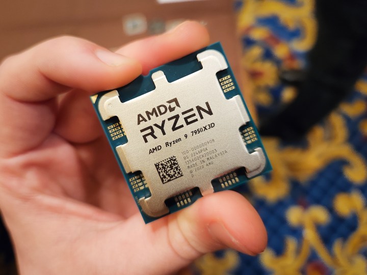 A hand holding AMD's Ryzen 9 7950X3D processor.