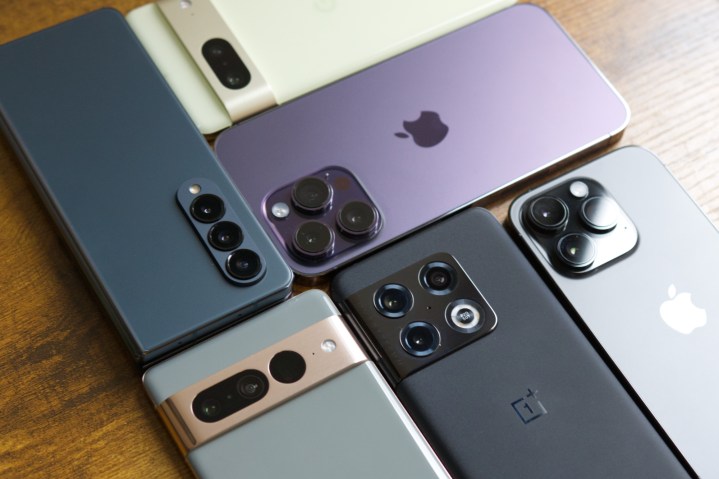 Google Pixel 7, iPhone 14 Pro Max, iPhone 14 Pro, Pixel 7 Pro, OnePlus 10 Pro, and Galaxy Z Fold 4 all lying on a table.