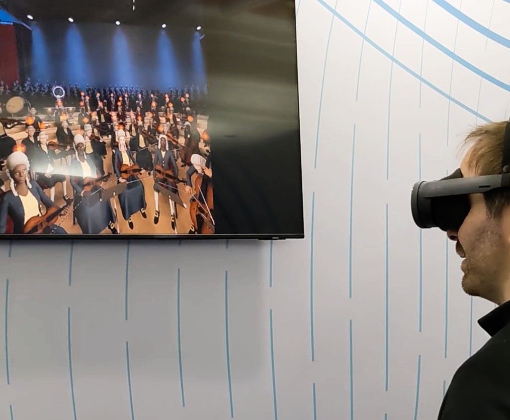 O jogo VR Maestro em uma tela na frente de alguém usando um HTC Vive XR Elite.