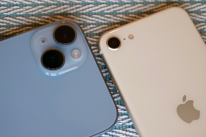 Primo piano dei moduli fotocamera di iPhone SE 2022 e iPhone 14 Plus.