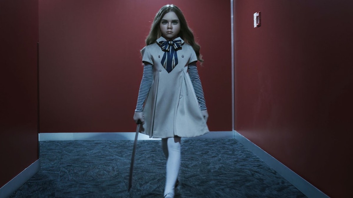 Uma boneca assassina caminha por um corredor em M3GAN.