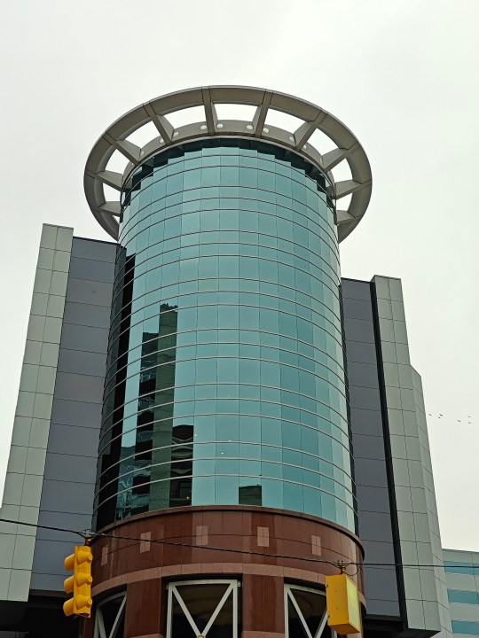 Zoomed in photo of a circular, glass building.