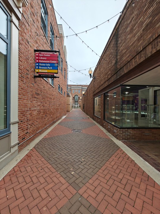 Photo of an alley with a brick walkway.