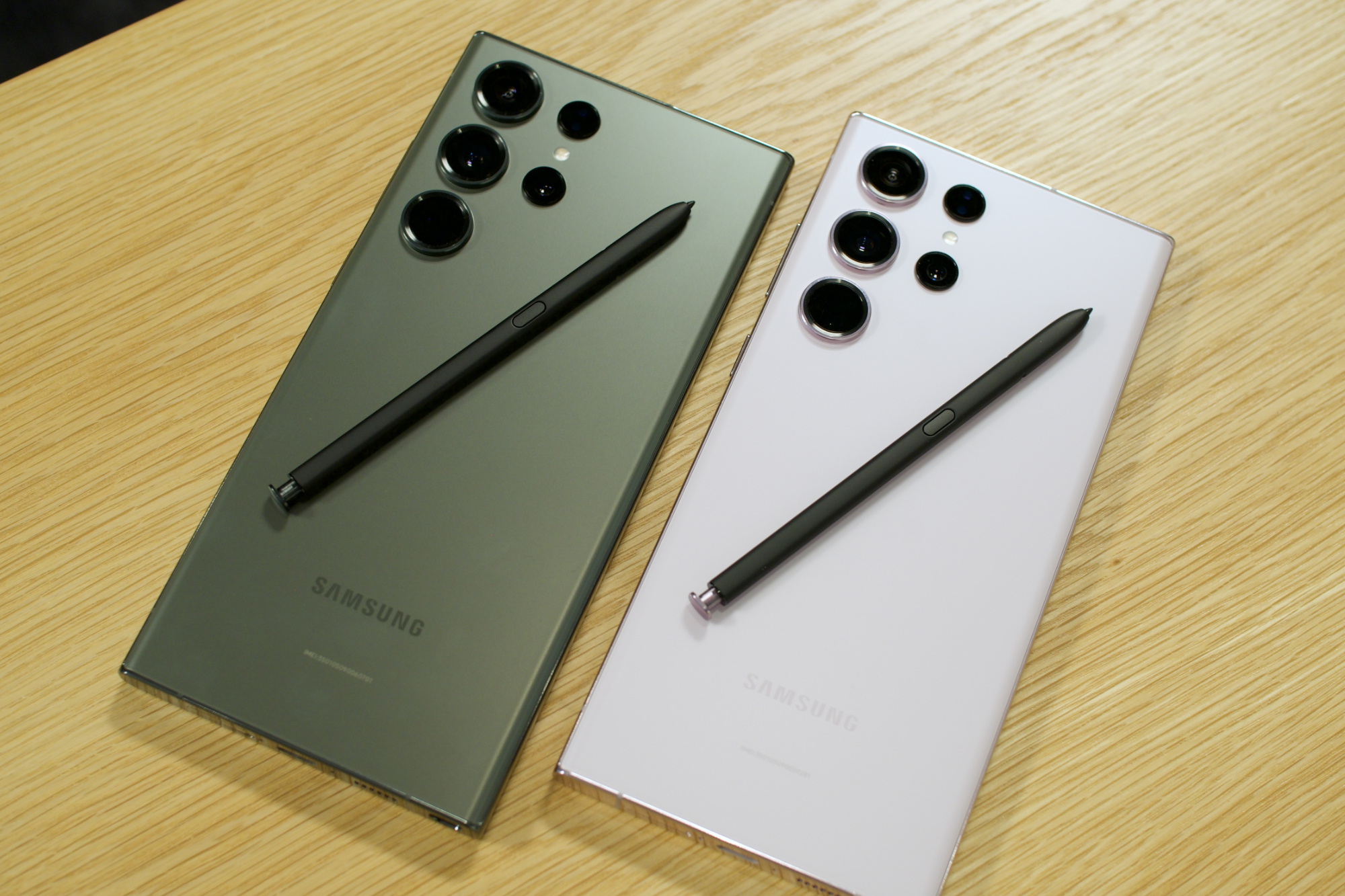 Dois telefones Samsung Galaxy S23 Ultra, ambos com uma S Pen na parte traseira.