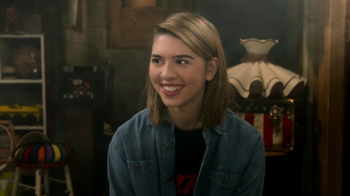 Leia Foreman smiling while sitting in the "basement circle" on That '90s Show.