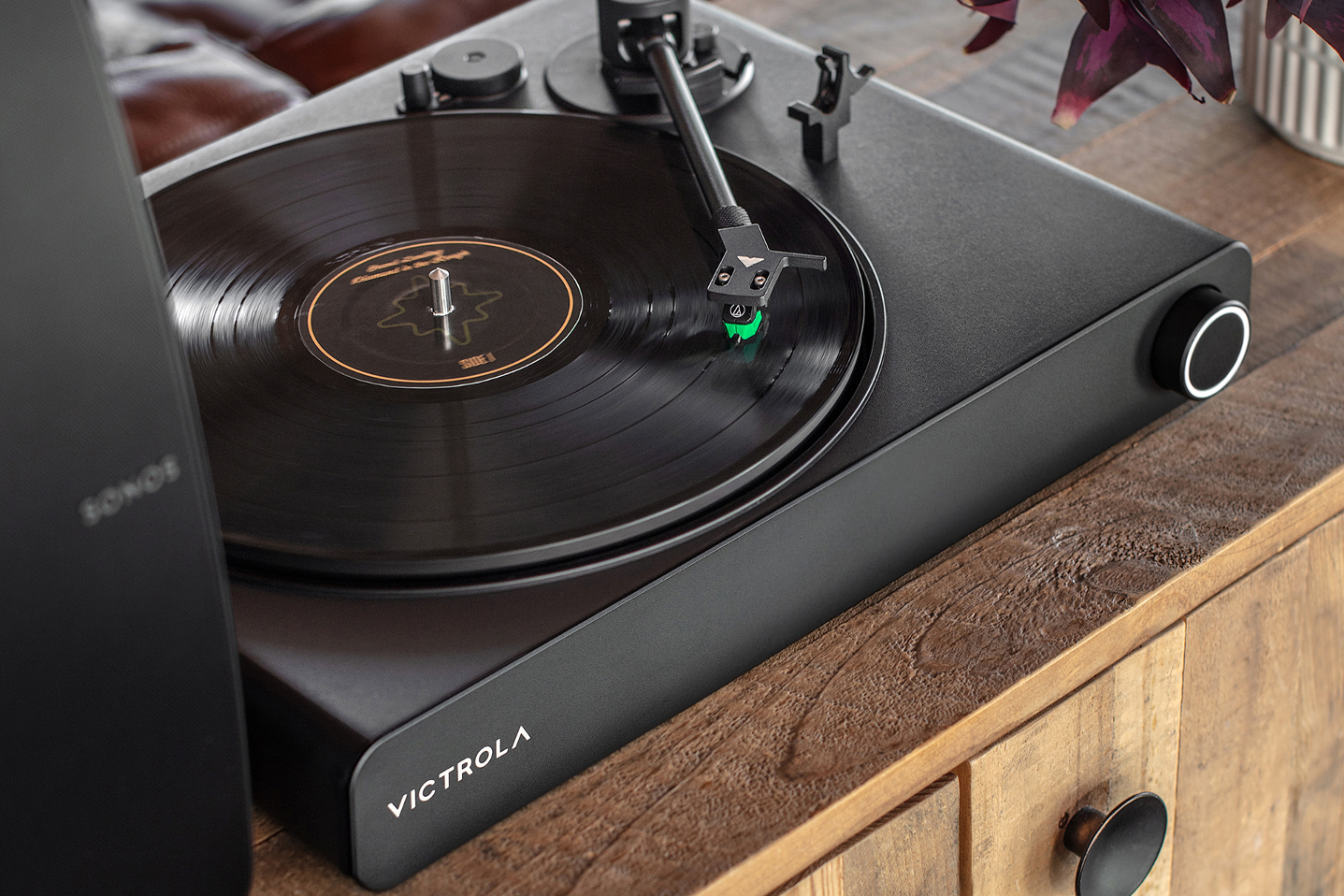 O toca-discos pronto para Vitrola Stream Onyx Sonos em um armário de madeira.