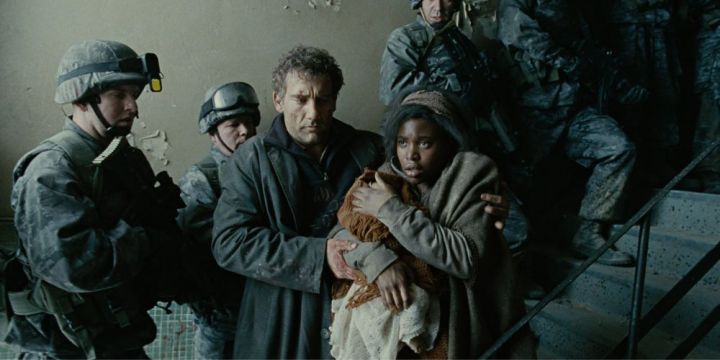 A pregnant woman is ushered through a hallway in Children of Men.