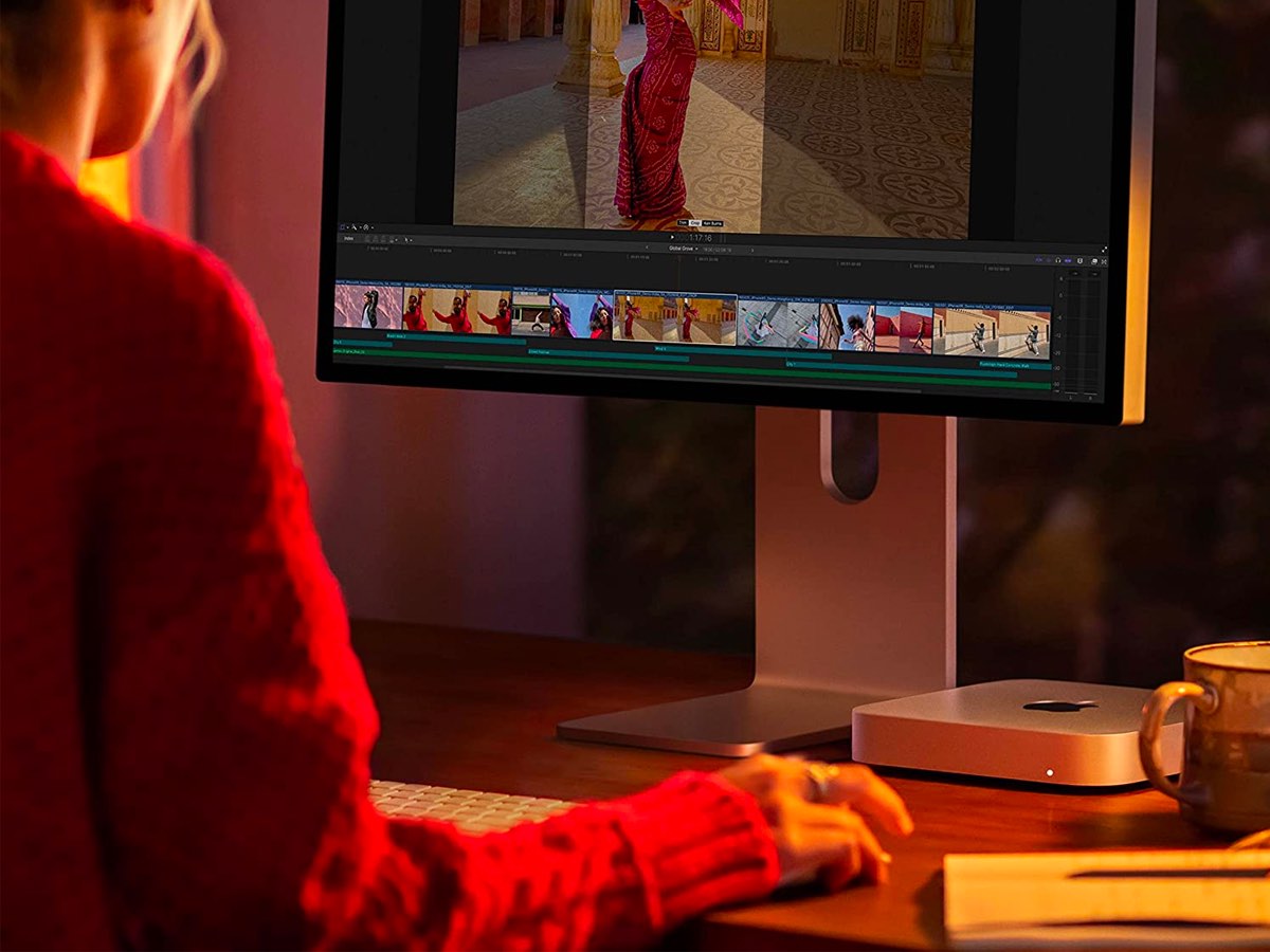 Una mujer trabaja en su escritorio en una computadora Apple Mac Mini M2.