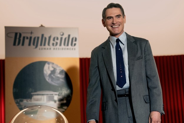 Billy Crudup stands near a Brightside poster in Hello Tomorrow.