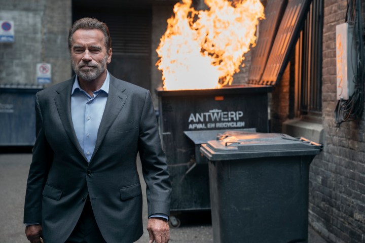 Arnold Schwarzenegger walks away from a dumpster on fire in Fubar.