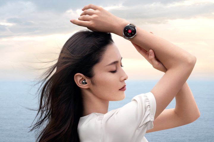 Person wearing the Huawei Watch Buds smartwatch and earbuds.
