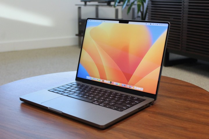 Das MacBook Pro aufgeschlagen auf einem Holztisch.
