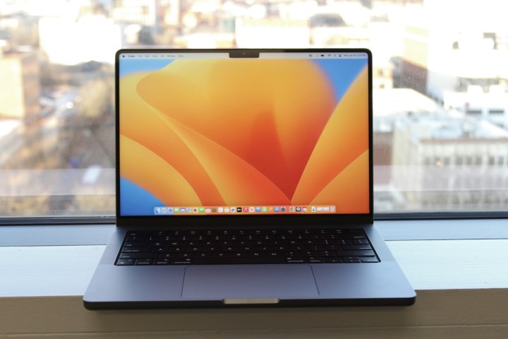 Le MacBook Pro 14 pouces sur le rebord d’une fenêtre.