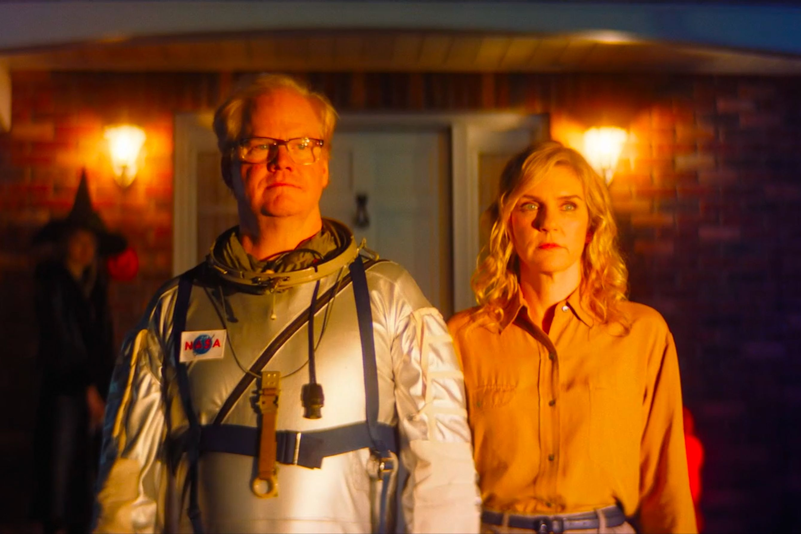जिम गैफ़िगन लिनोलियम में रिया सीहॉर्न के बगल में खड़े होकर एक स्पेस सूट पहनते हैं।