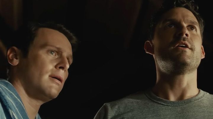 Two scared looking men standing and looking ahead in the film Knock at the Cabin.