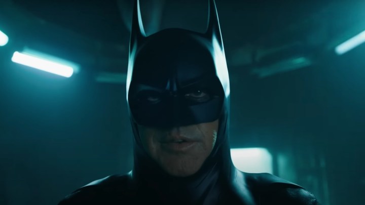 Um homem como Batman se levanta e olha fixamente em The Flash.
