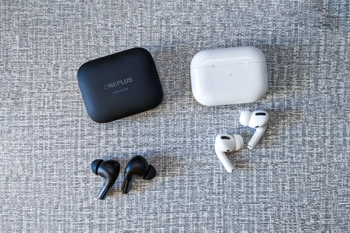 OnePlus Buds Pro 2 مشکی و نسل اول AirPods Pro در رنگ سفید روی میز سفید و خاکستری.