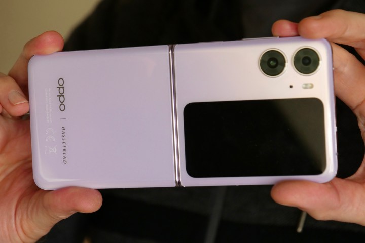Holding the open Oppo Find N2 Flip, seen from the back.
