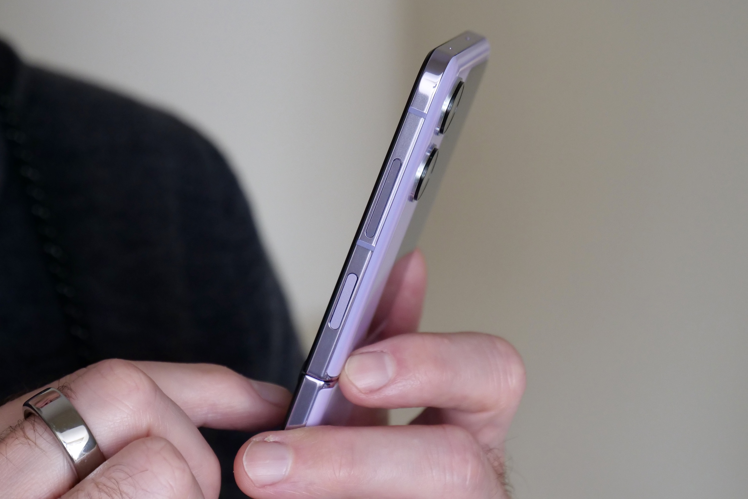 The side of the open Oppo Find N2 Flip, held in a person's hand.