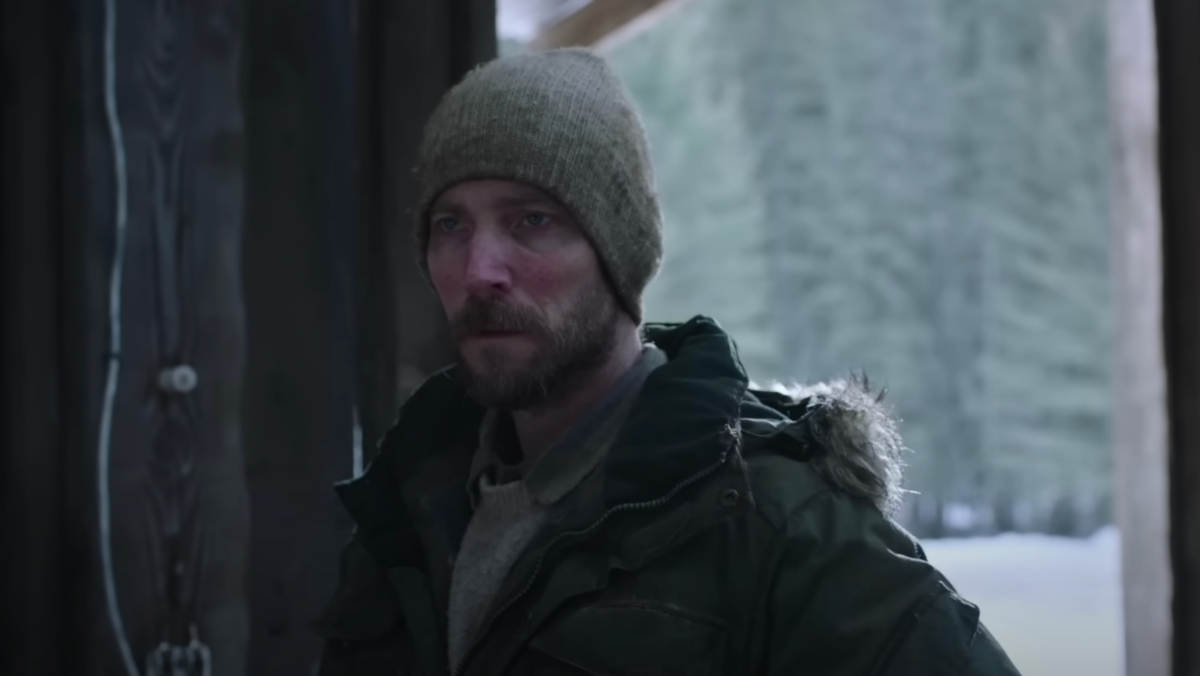 Um homem se levanta e olha fixamente em The Last of Us.