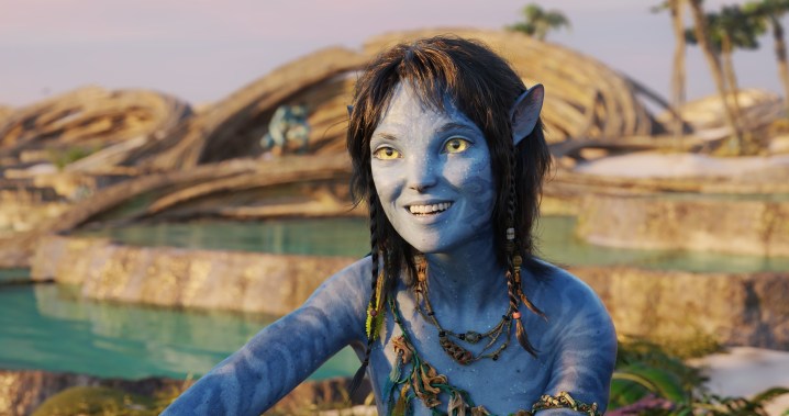 A smiling Na'vi looks at the camera in Avatar: The Way of Water.