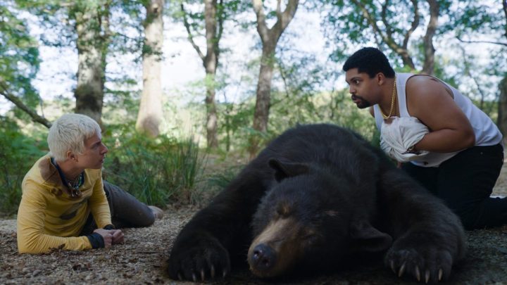 Aaron Holliday and O'Shea Jackson Jr. stare at each other over the body of a bear collapsed between them.