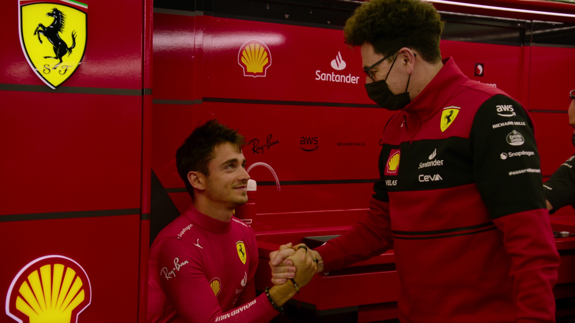 O piloto da Ferrari, Charles Leclerc, e o chefe da equipe, Mattia Binotto, apertam as mãos em uma cena da 5ª temporada da Fórmula 1: Drive to Survive.