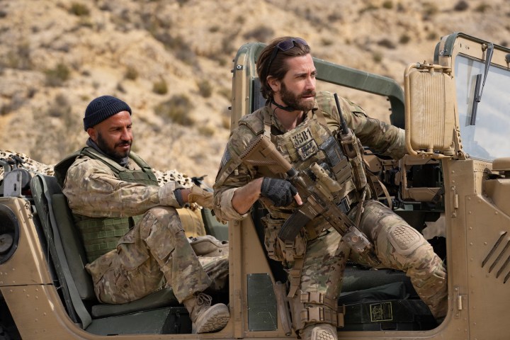 Jake Gyllenhaal se sienta al costado de un jeep en una escena de The Covenant.
