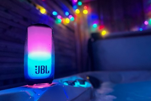 The LBL Pulse 5 Bluetooth speaker sitting on a hot tub ledge.