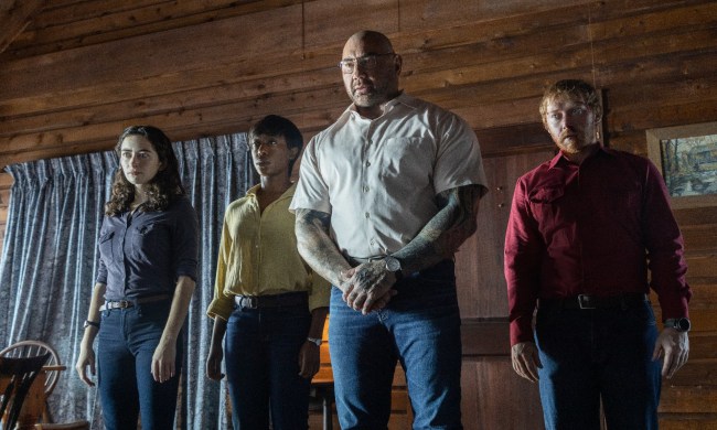 Abby Quinn, Nikki Amuka-Bird, Dave Bautista, and Ruprt Grint stand grimly inside a cabin, staring at the camera.