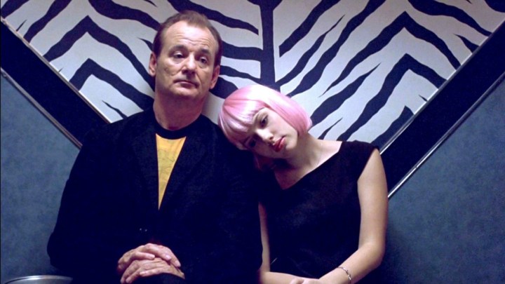 Bill Murray sitting down, Scarlett Johansson beside him with her head on his shoulder in a scene from Lost in Translation.
