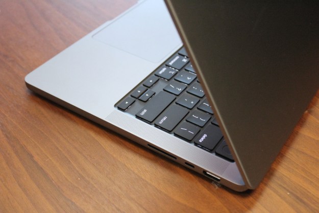 The keyboard of the MacBook Pro 14-inch on a wood surface.