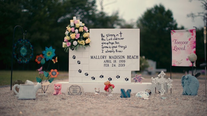 Mallory Beach's gravesite, surrounded by flowers and stuffed animals in a scene from Murdaugh Murders.