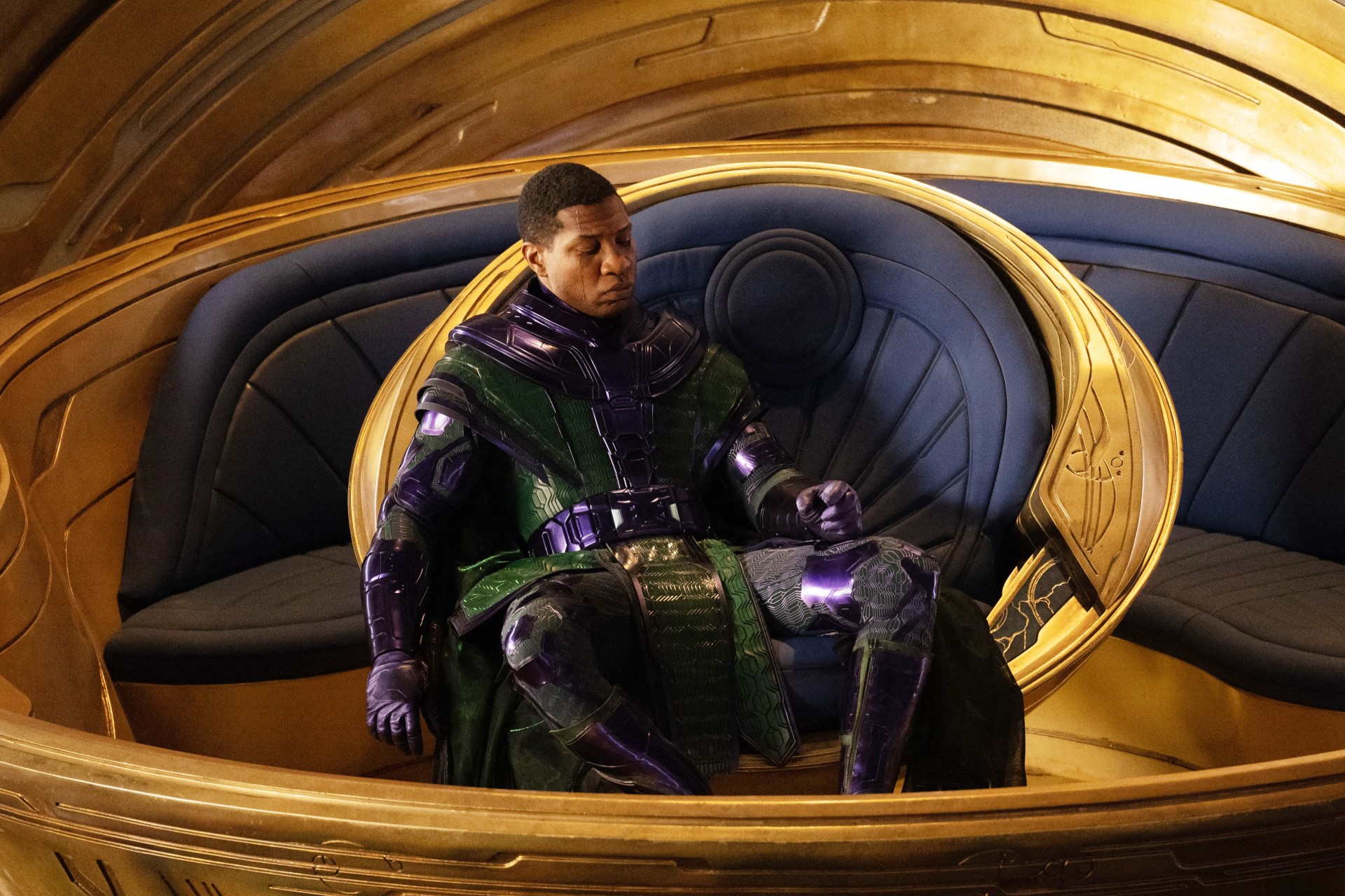 Kang está sentado em sua cadeira em Homem-Formiga e a Vespa: Quantumania.