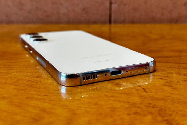 سامسونگ گلکسی اس 23 روی یک میز قرار گرفته و درگاه شارژ USB-C و گریل های بلندگو را نشان می دهد.