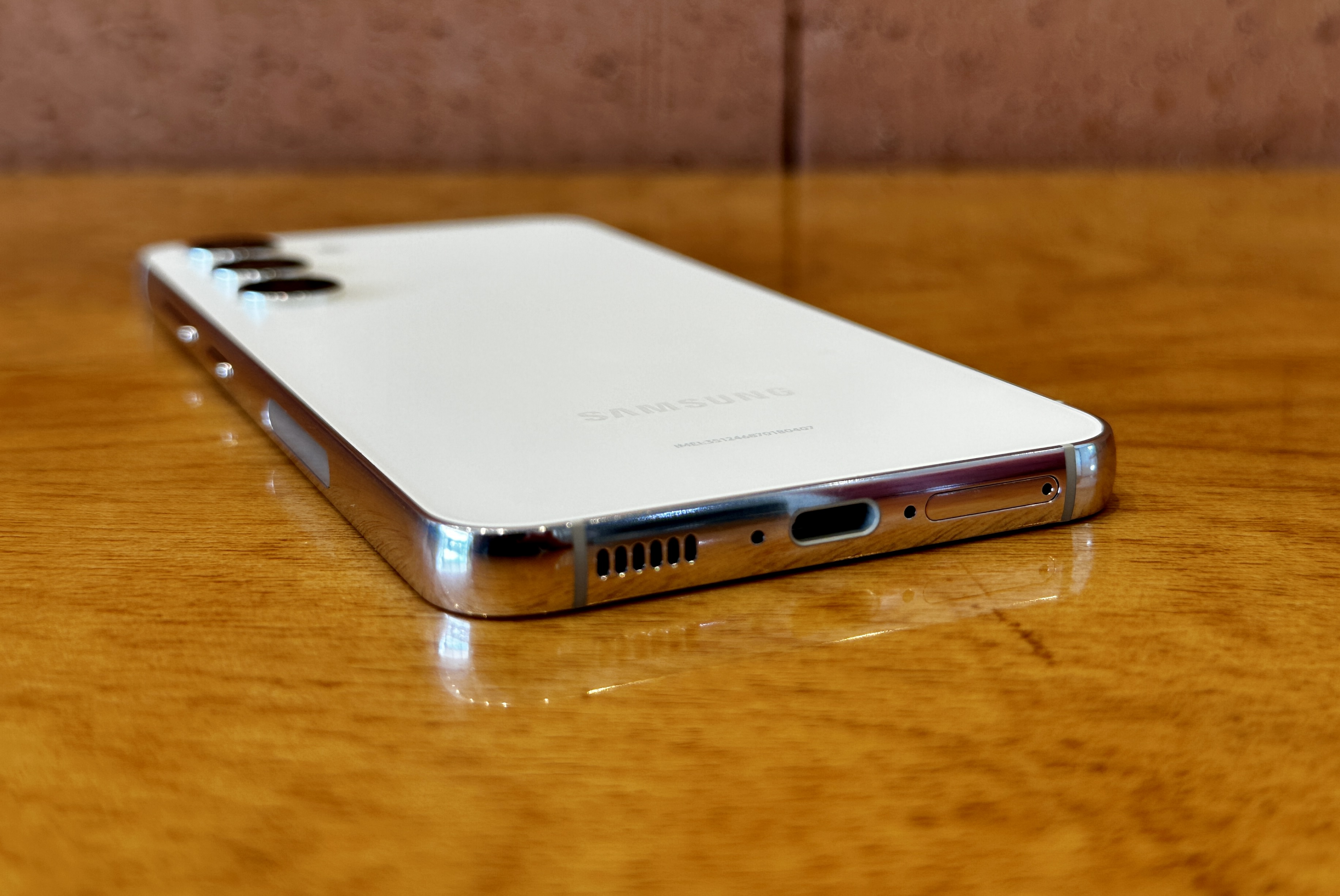 Samsung Galaxy S23 deitado sobre uma mesa exibindo a porta de carregamento USB-C e as grades dos alto-falantes