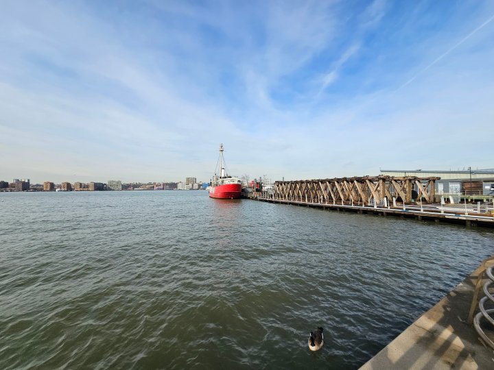 Wide-angle photo from the Galaxy S23 Ultra, showing a red boat by a dock on the water.