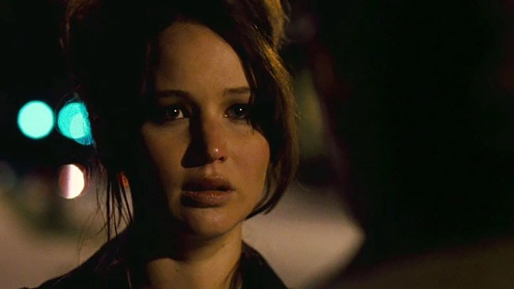 Jennifer Lawrence con lágrimas en los ojos mirando a alguien en una escena de Silver Linings Playbook.
