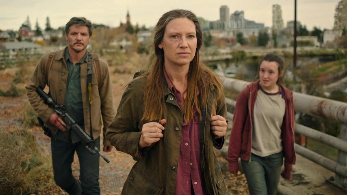 Uma mulher caminha à frente de um homem e uma garota em The Last of Us.