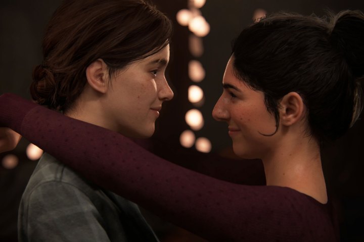 A screenshot from The Last of Us Part 2 of Ellie and Dina slow dancing with one another.