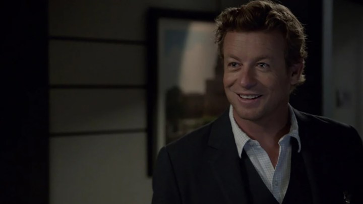 The main character from The Mentalist in a black blazer and white shirt, smiling.