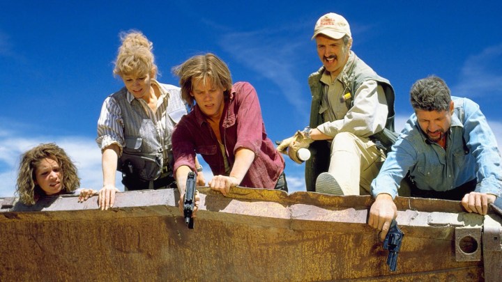 A group of point people point guns at the earth in Tremors.