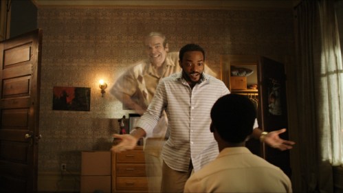 David Harbour, as a ghost, peeks out from behind Anthony Mackie in a scene from We Have A Ghost.