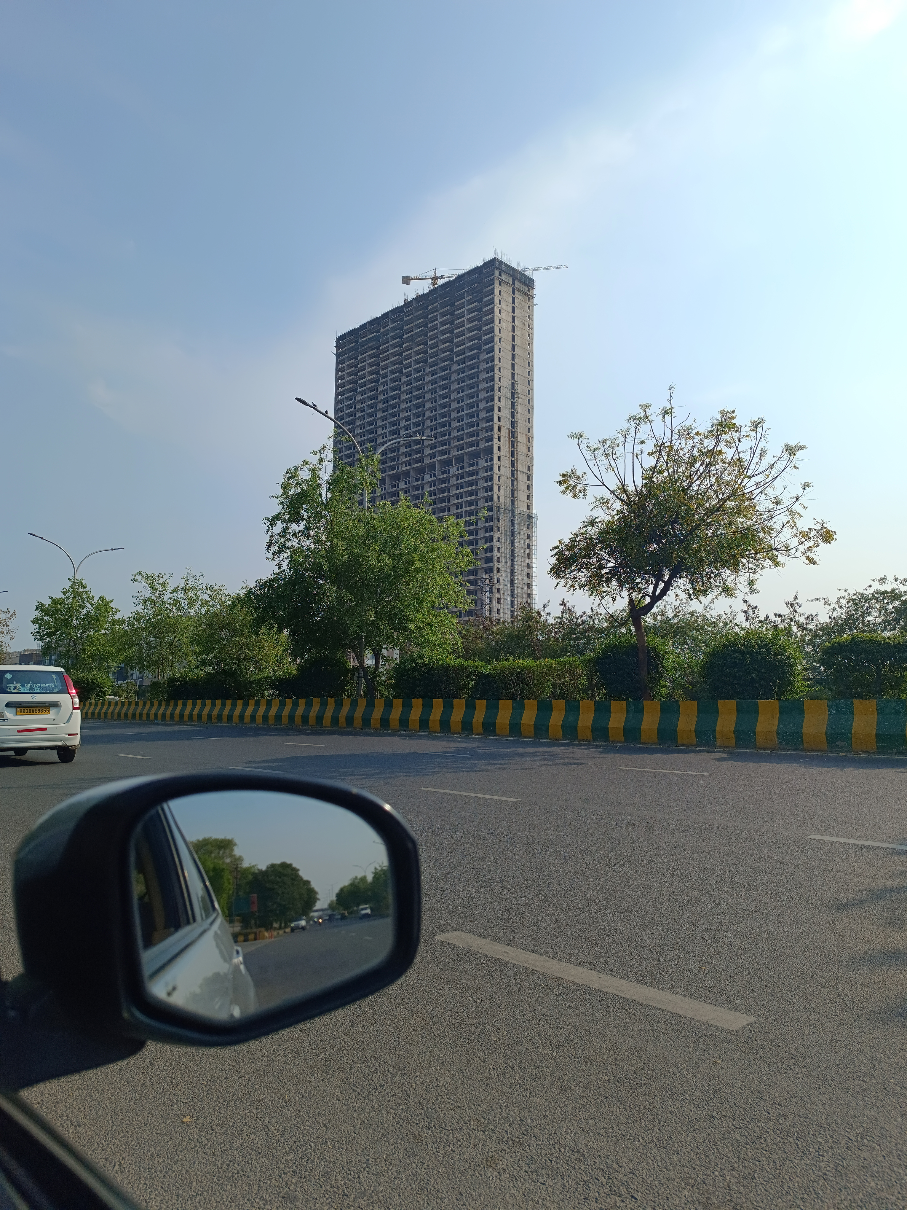Multi-storey building under construction on the side of a road captured by Redmi Note 12 Pro Plus.