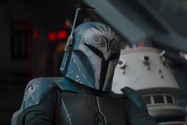 Bo-Katan se sienta cerca de un droide astromecánico R5 en el episodio 3 de la temporada 3 de The Mandalorian.